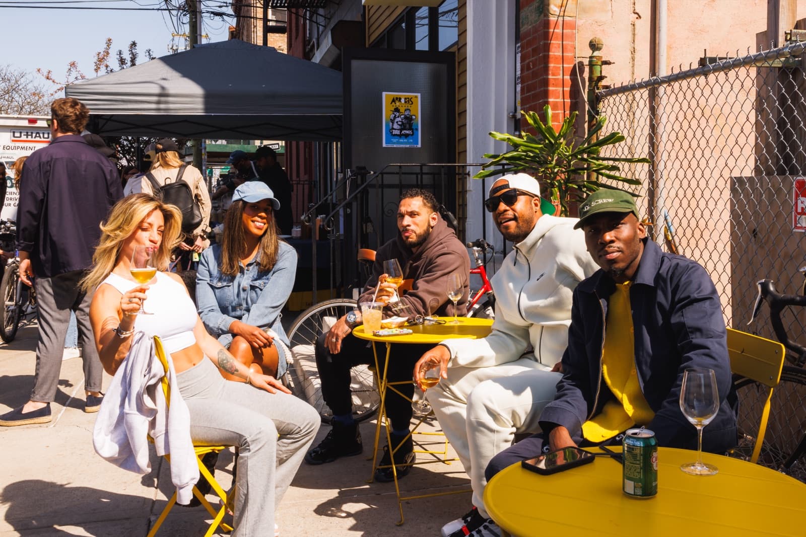 Guests toasting at yellow sidewalk tables during an Arroces outdoor event